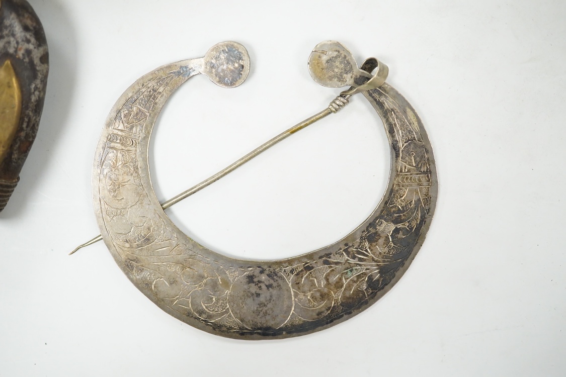 A niello work belt buckle, 21cm wide, an Arab white metal cloak brooch and a powder flask